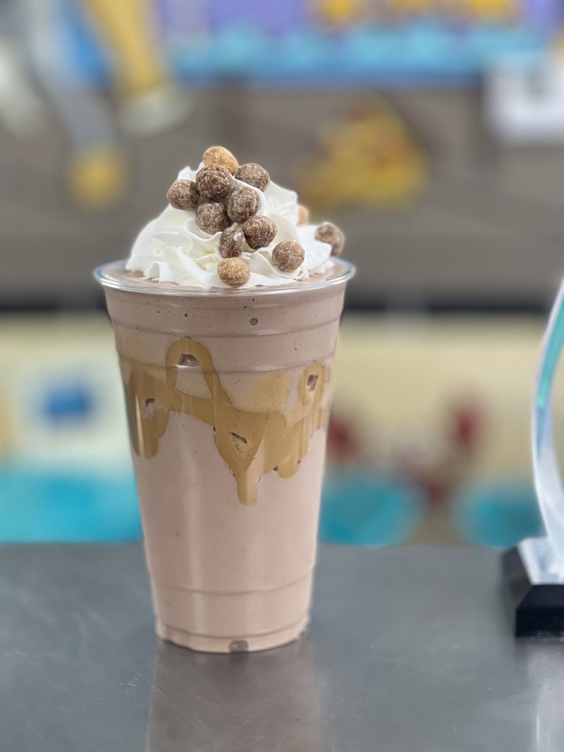 Chocolate milkshake topped with whipped cream and cereal balls