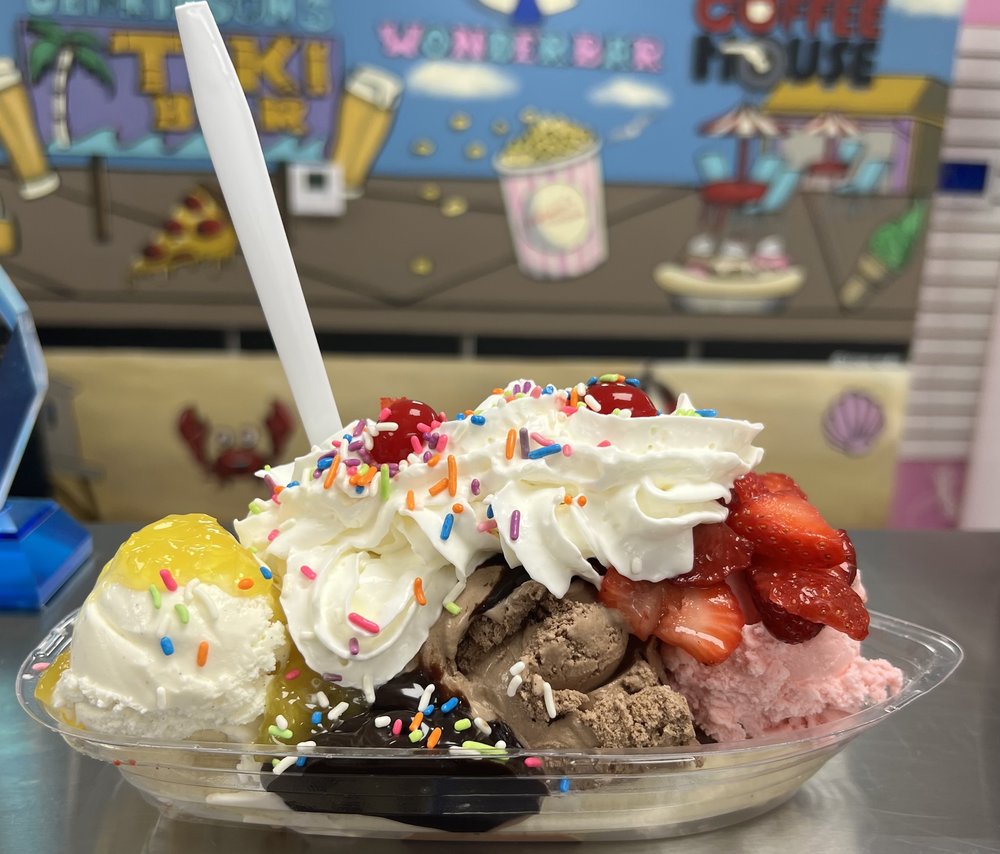 Loaded banana split sundae with whipped cream, sprinkles, cherries and strawberries